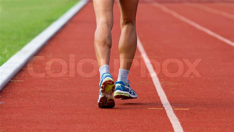 Male jogging at a track and field stadium, stock photo