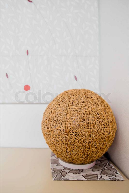 Wood, rattan lamp on the desk in the corner of the room, stock photo