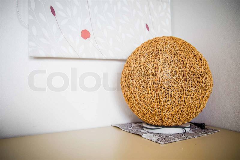 Wood, rattan lamp on the desk in the corner of the room, stock photo