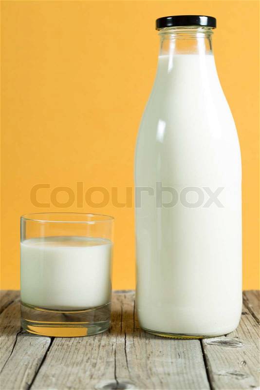 Milk bottle on a table with color background, stock photo