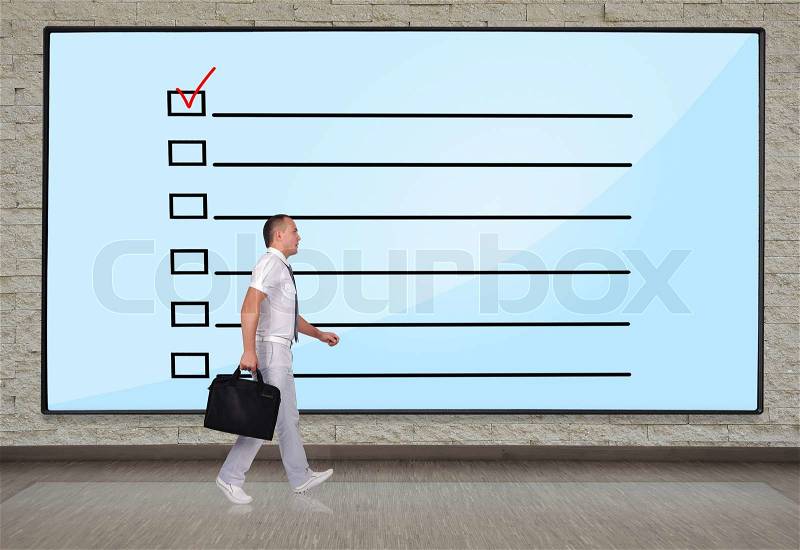Businessmen walking at big plasma panel with check box on wall, stock photo