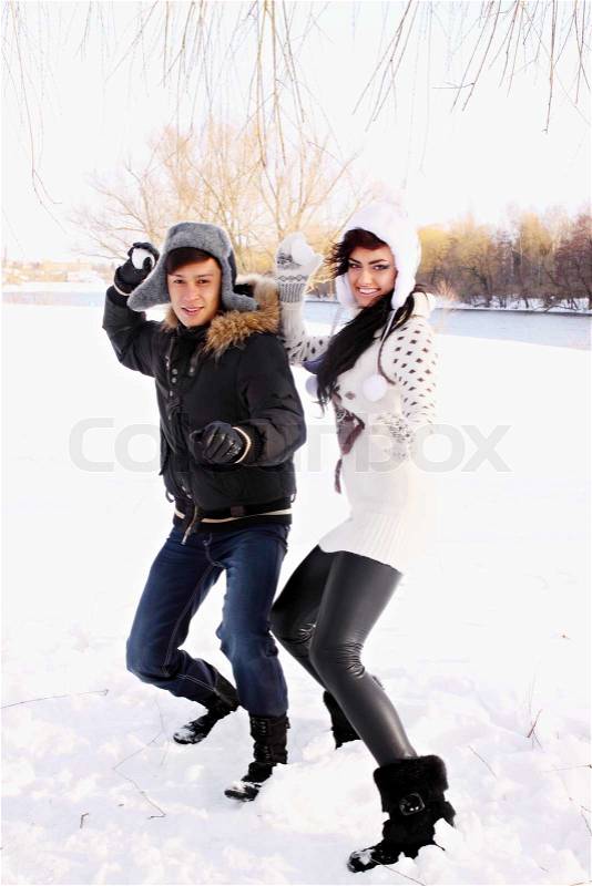 Couple throwing snowballs, stock photo