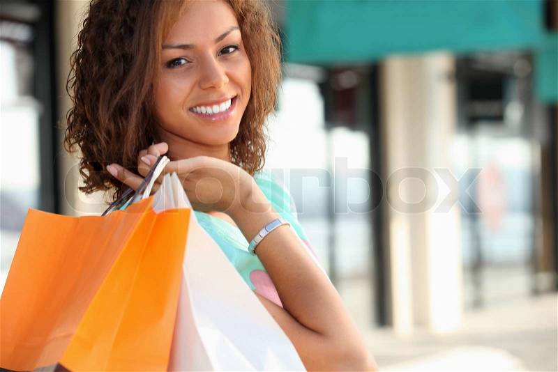 Smiling Metis woman carrying shopping bags, stock photo