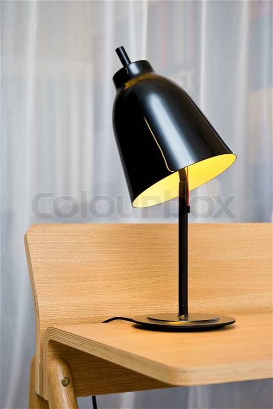 Detail of modern design lamp on a wooden desk, stock photo