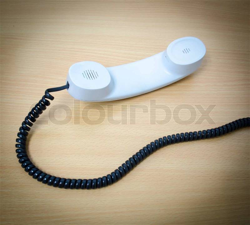 Elevated View of a white Telephone Receiver on a wooden table,, stock photo