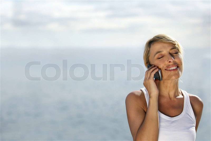 Woman on telephone at the beach, stock photo