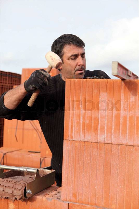 Man hitting wall with mallet, stock photo