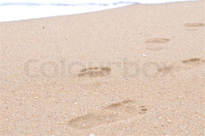 Human footprints on the sand beach, stock photo