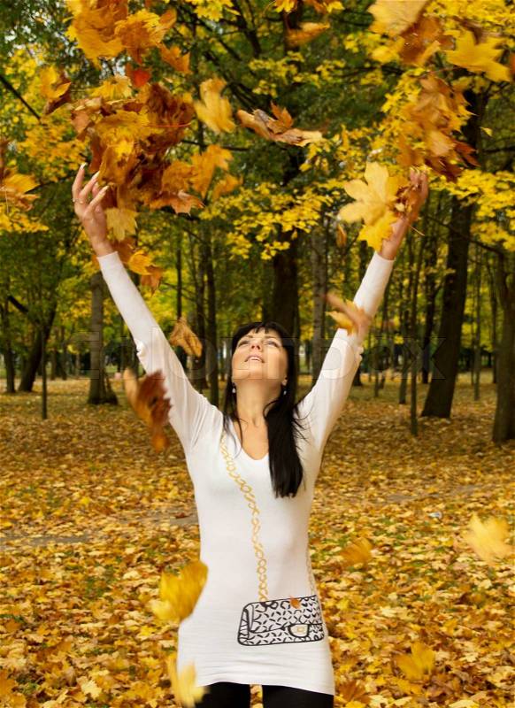 A girl throws leaves on the nature, stock photo