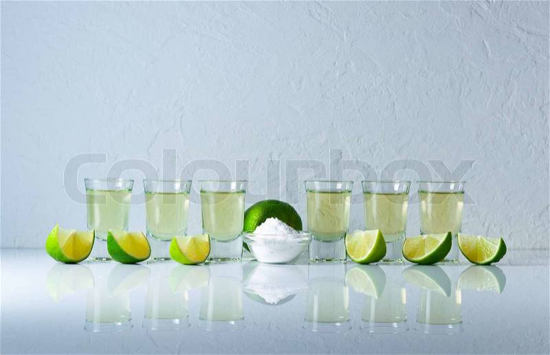 Tequila , lime and salt on white reflexive table, stock photo