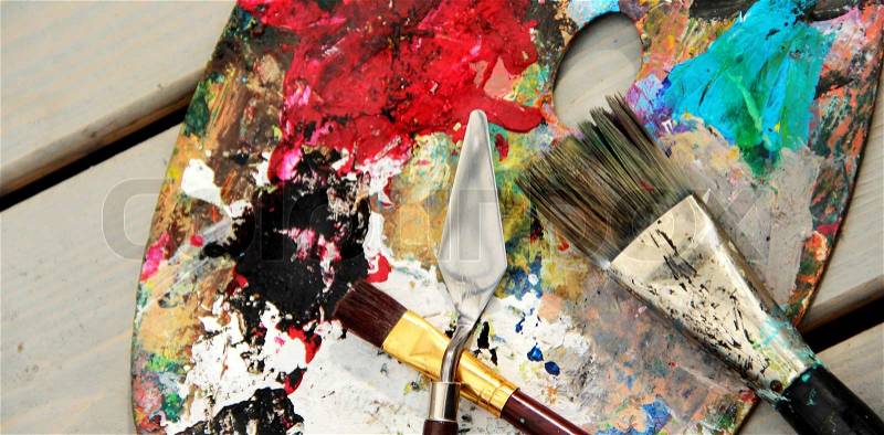 Art palette and brushes with a lot of vivid colors , stock photo