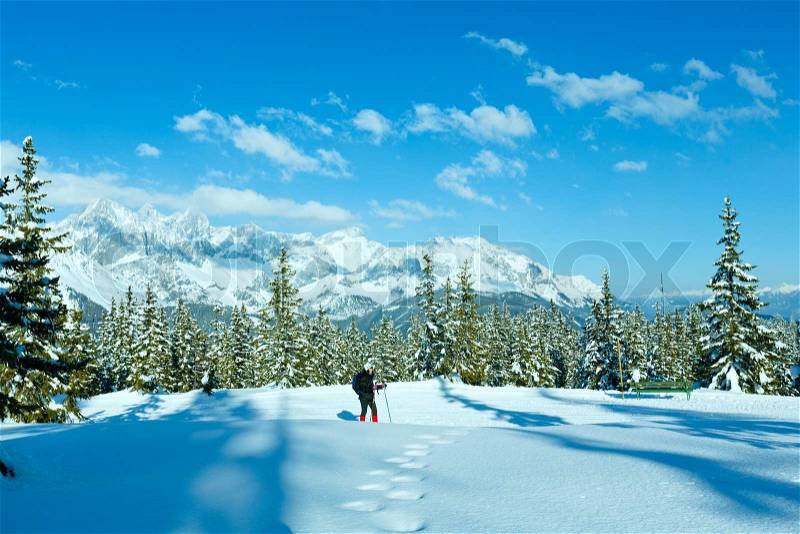 Winter mountain landscape and woman on walk top of Papageno bahn - Filzmoos, Austria, stock photo