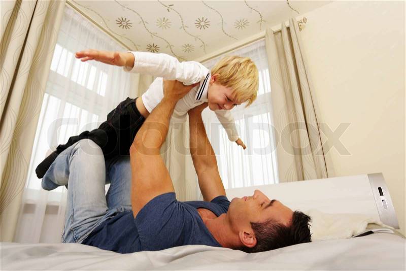 Father and son playing at home. Flying concept, stock photo
