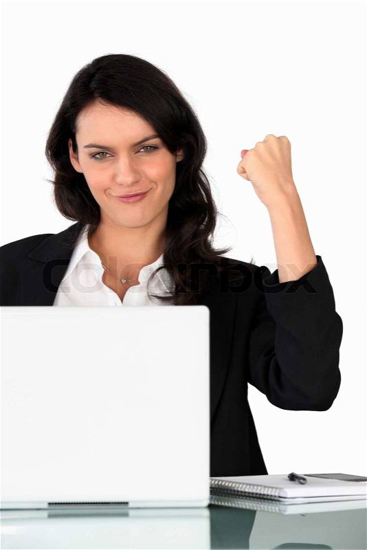 Businesswoman holding a triumphant fist in the air, stock photo
