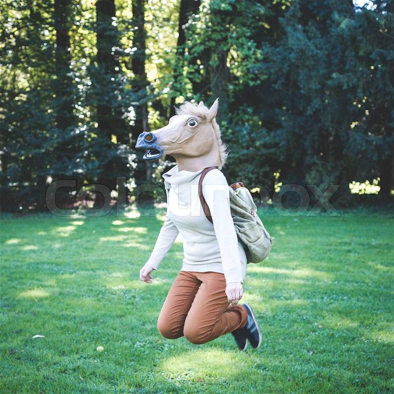 Young hipster horse mask woman in the woodland autumn, stock photo