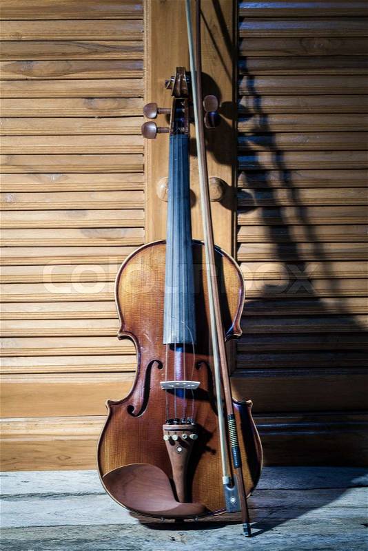Broken violin on wooden floor, stock photo