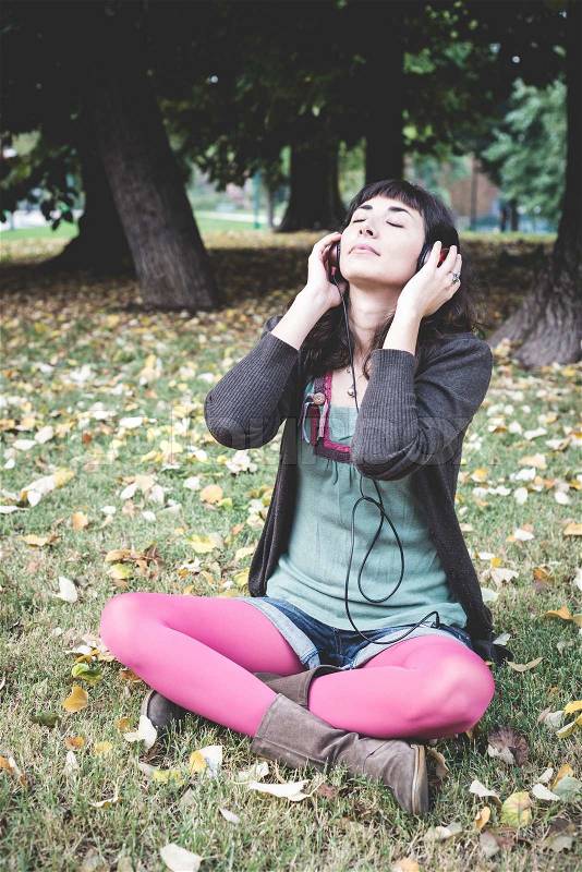 Young beautiful woman listening to music autumn, stock photo