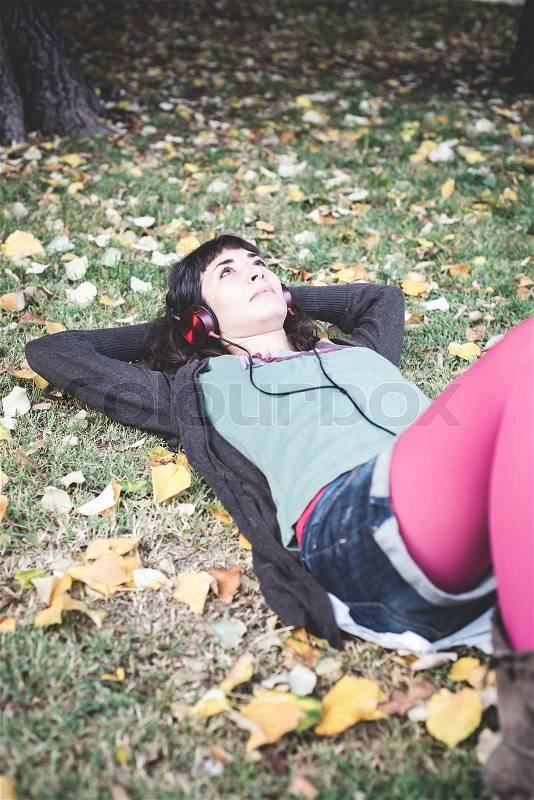 Young beautiful woman listening to music autumn, stock photo