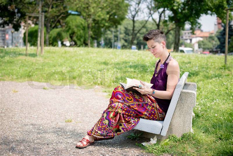 Beautiful hipster short hair woman in the park in the city, stock photo