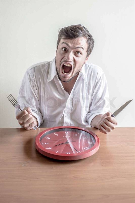 Young stylish man with white shirt eating red clock, stock photo