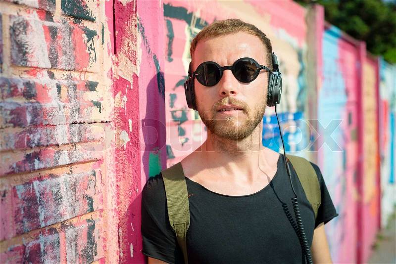 Hipster modern stylish blonde man listening music in daily life, stock photo
