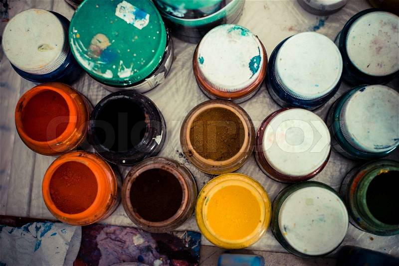 Colored jars of powder paint in a painter studio, stock photo