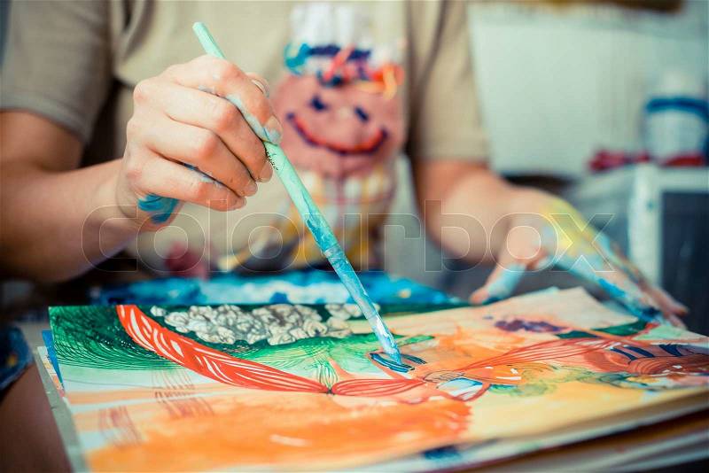 Particular of woman painter hand painting in her studio, stock photo
