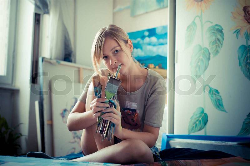 Beautiful blonde woman painter in her studio, stock photo