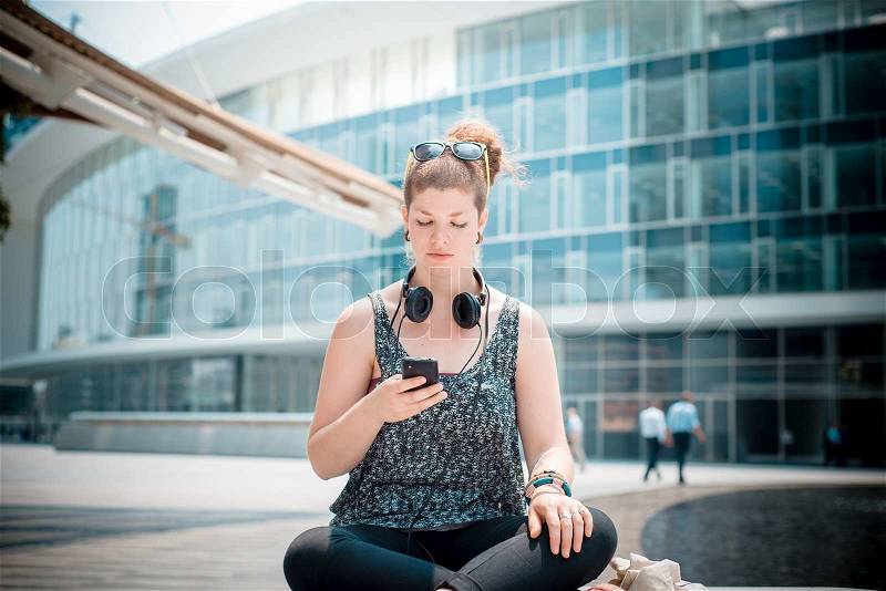 Beautiful stylish modern young woman on the phone in the city, stock photo