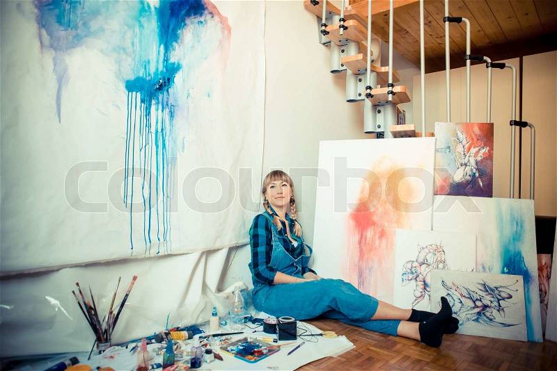 Beautiful blonde woman painter in her studio, stock photo