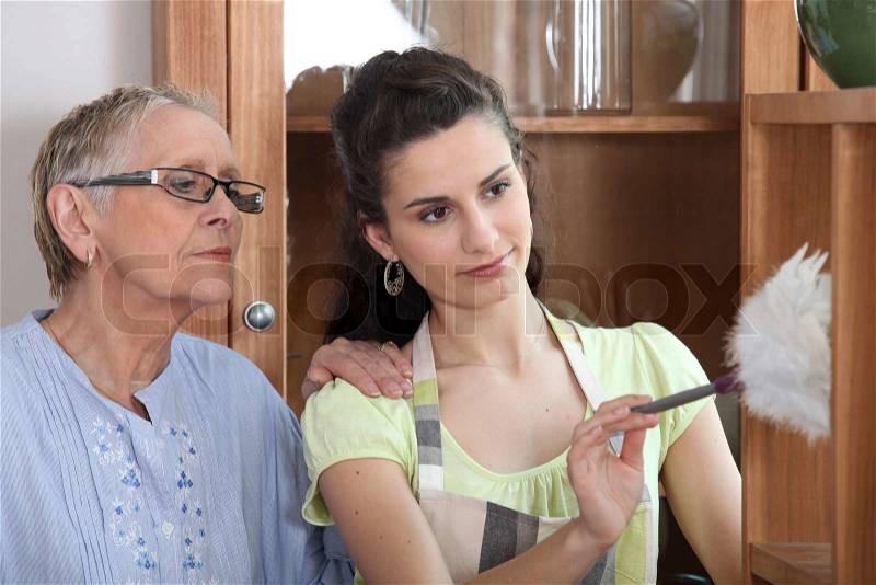 Young woman helping senior lady with the cleaning, stock photo