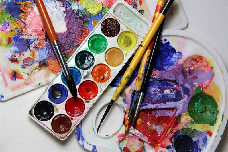 Art palette and brushes with a lot of vivid colors , stock photo