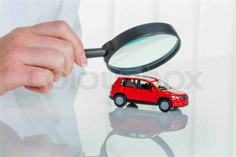 A model of a car is examined by a doctor. photo icon for workshop, service and car buying, stock photo