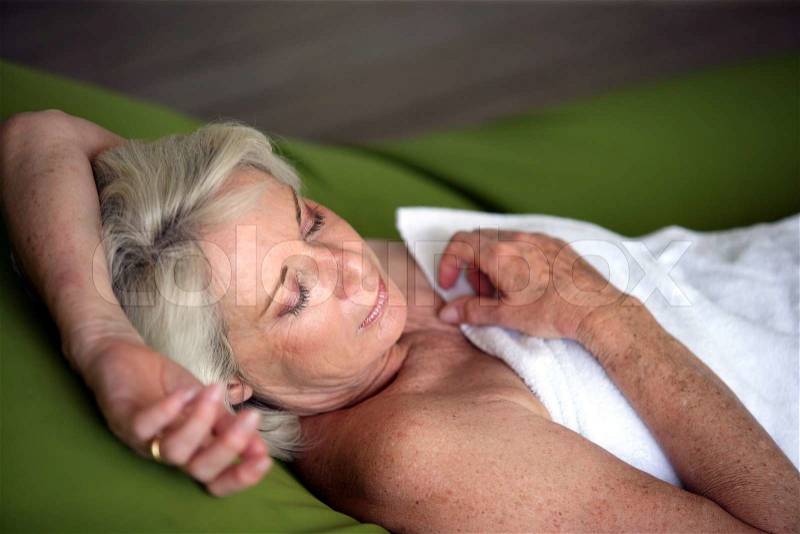 Senior woman asleep in a towel, stock photo