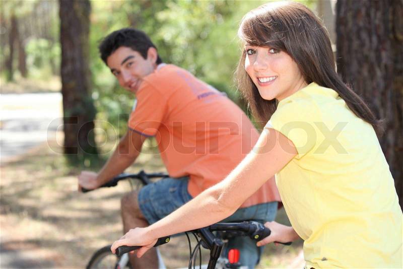 Young people biking in the forest, stock photo