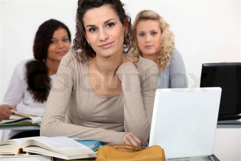 Three female students studying with their laptops, stock photo