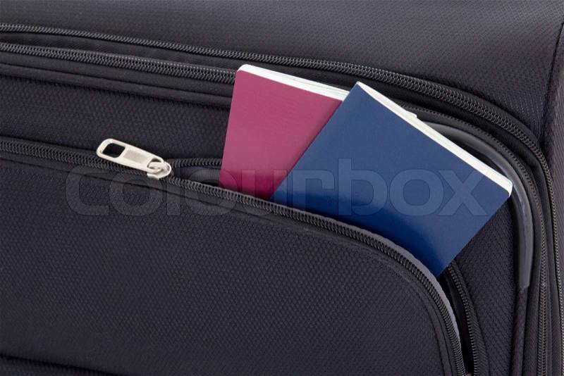 Close up of black travel suitcase and two passports, stock photo