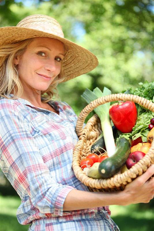Woman holding basket of vegetables, stock photo