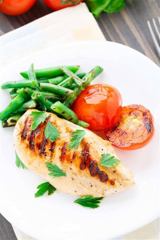 Grilled chicken with green beans and tomatoes, stock photo
