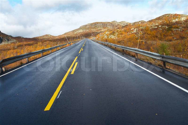 Empty mountain road road receding into the distance at the cloudy autumn day , stock photo