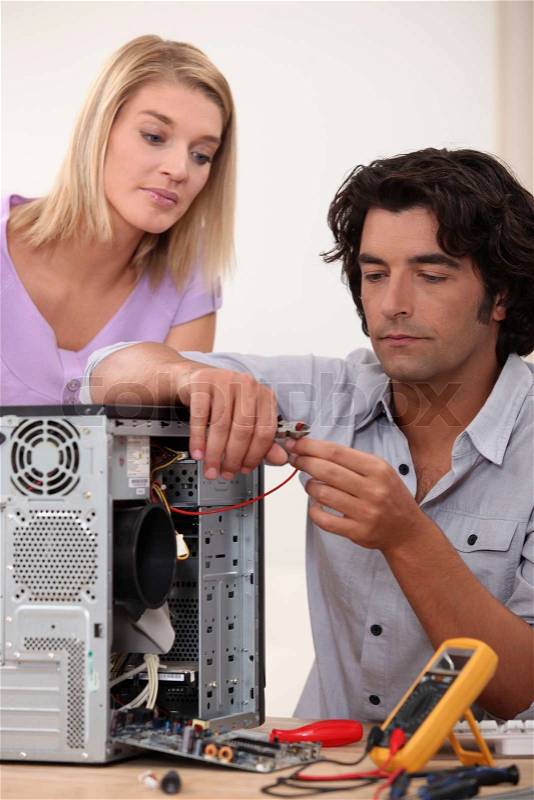 Man repairing PC for colleague, stock photo