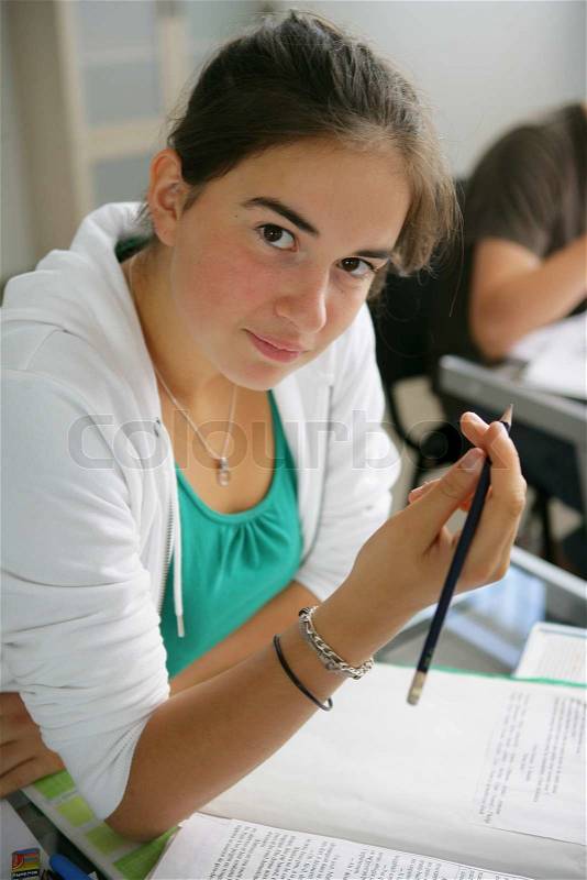 Teenage girl writing in an exam, stock photo