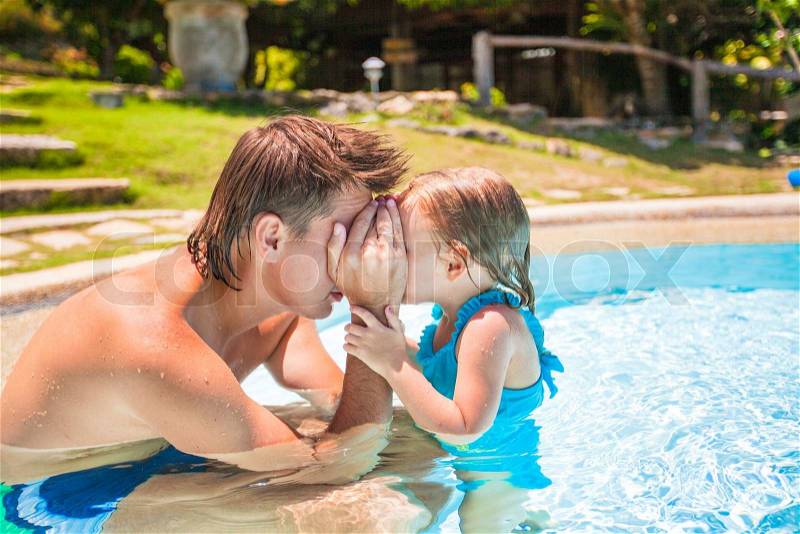 Little cute girl play with father at the pool in tropical hotel, stock photo