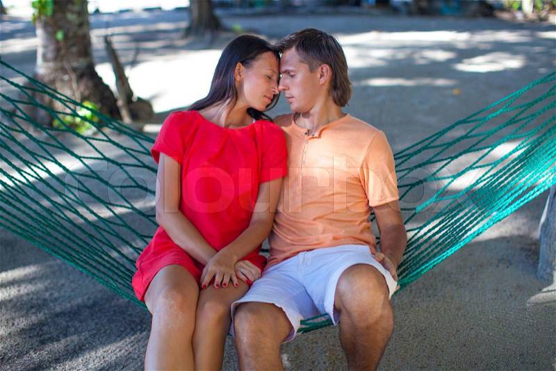 Portrait of Young loving couple in a hammock at exotic resort, stock photo