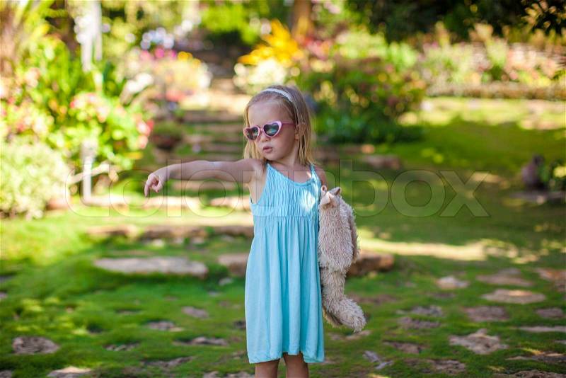Little girl walking in tropical green hotel, stock photo