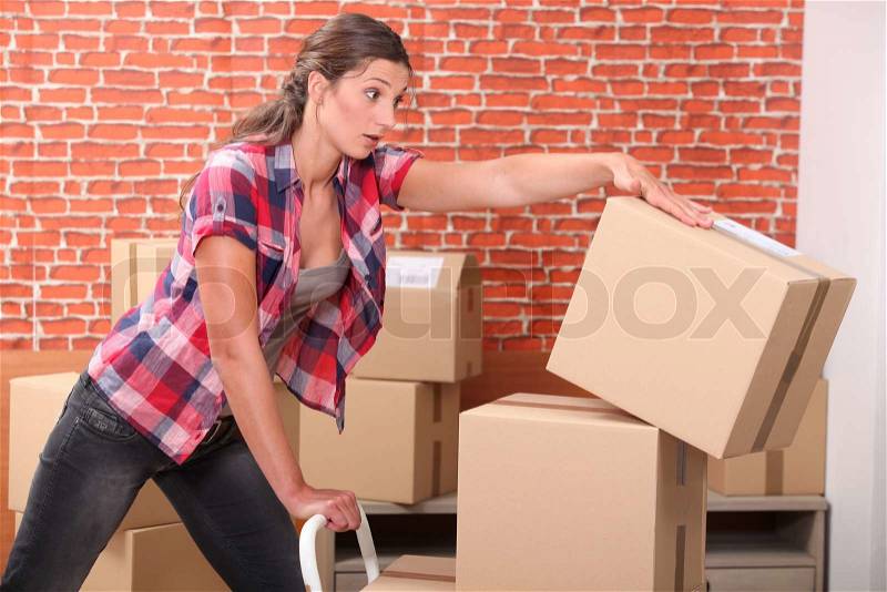 Woman dropping packing boxes, stock photo