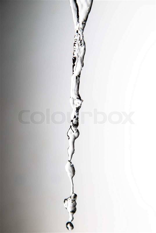 A jet of water on a gray background, stock photo