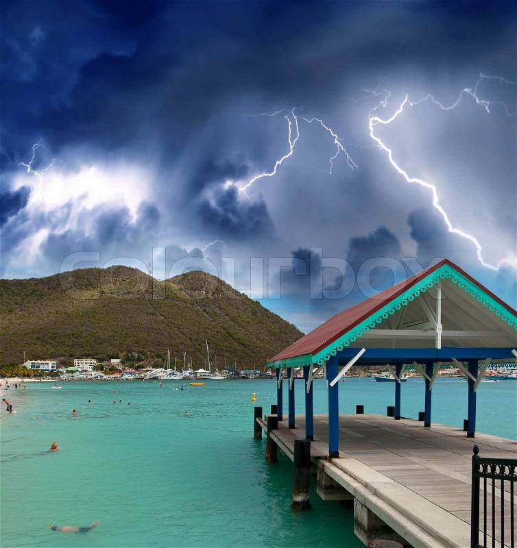 Thunderstorm over beautiful beach with jetty over water, stock photo