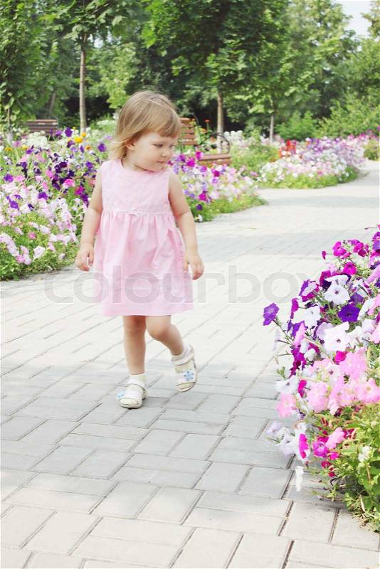 Girl walks on a flowers alley, stock photo