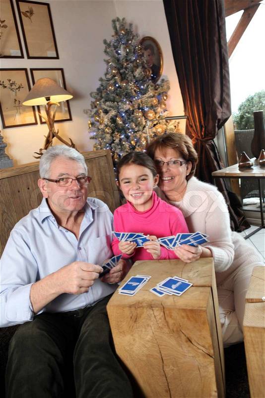 Grandparents playing game with little girl, stock photo